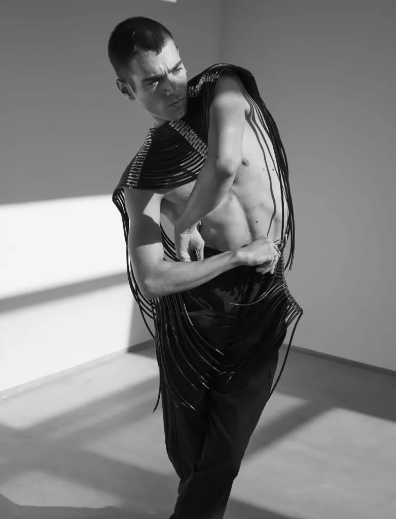 Alex Peacock en una pose de danza con vestuario negro